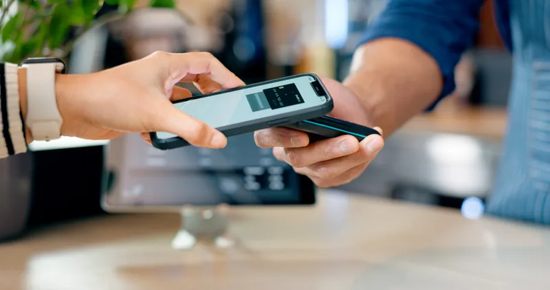 Customer making a contactless payment at a cafe using Teya terminal