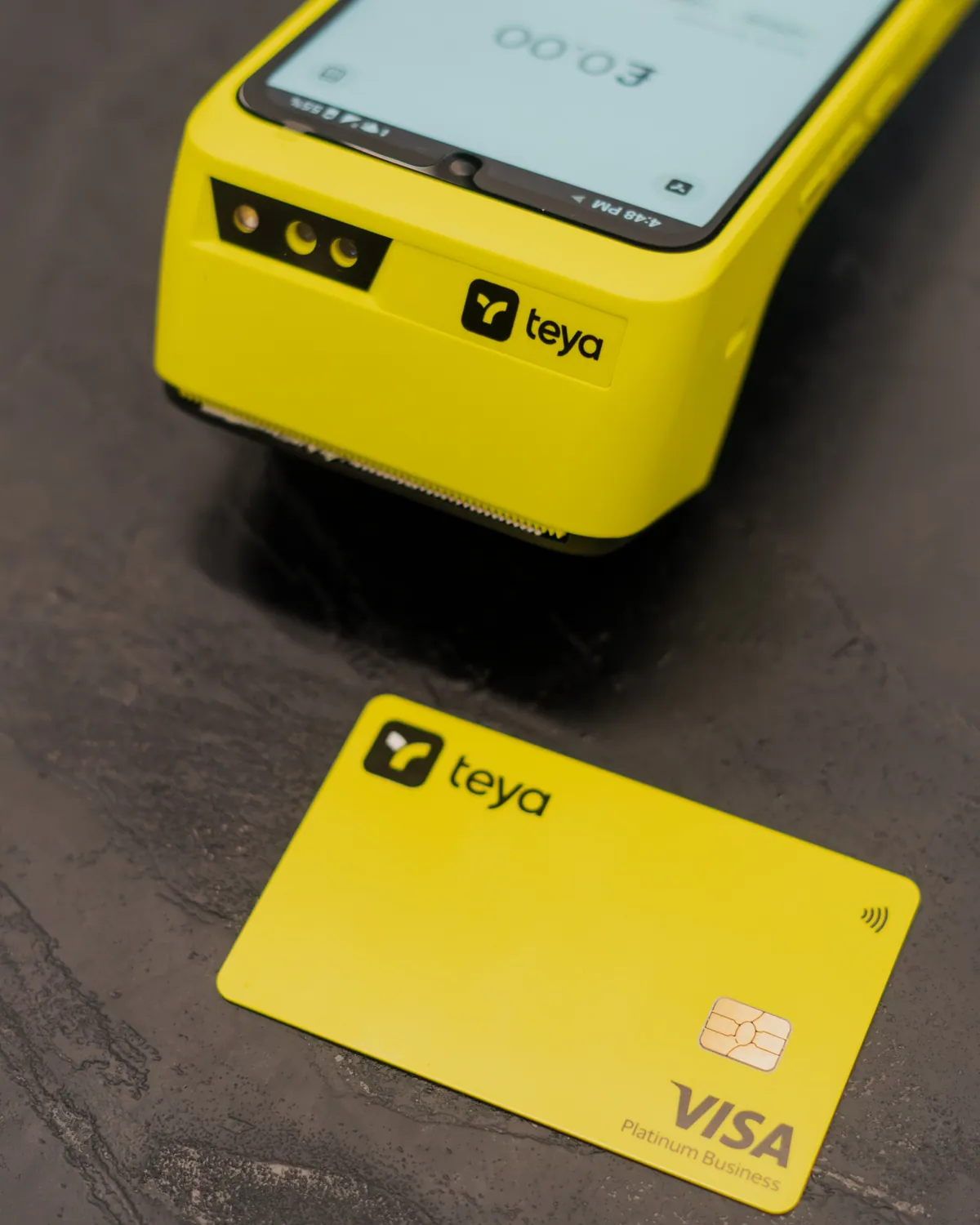 A Teya card terminal with a Teya Visa business card resting on a dark surface